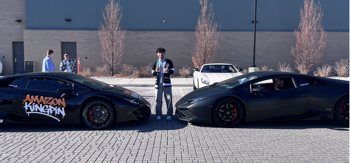 Haroon Javid poses between two sports cars